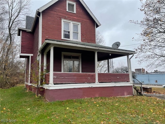 view of home's exterior featuring a lawn and covered porch