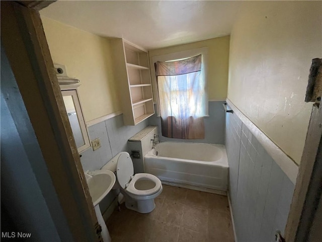 bathroom with a tub, tile walls, and toilet