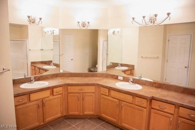 bathroom featuring tile patterned floors, a shower, vanity, and an inviting chandelier