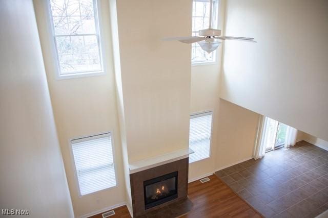 unfurnished living room featuring ceiling fan and dark hardwood / wood-style flooring