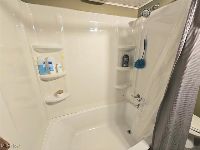 bathroom with toilet and shower / tub combo with curtain