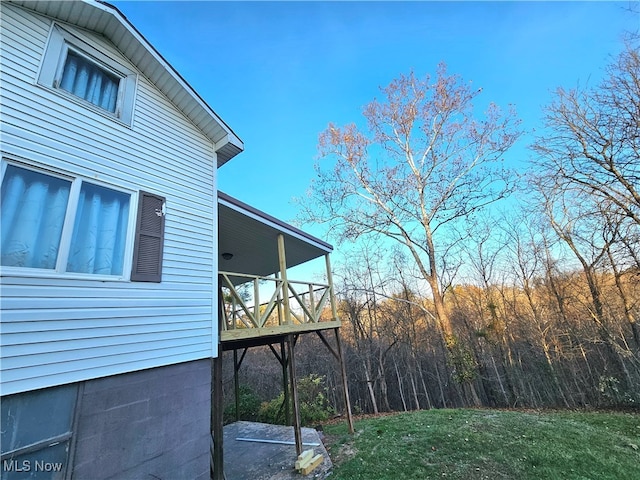 view of property exterior with a lawn and a balcony