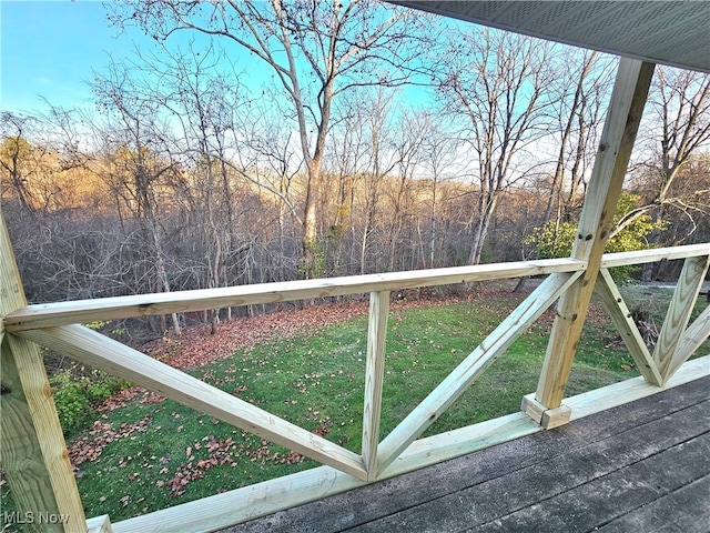 wooden deck featuring a lawn