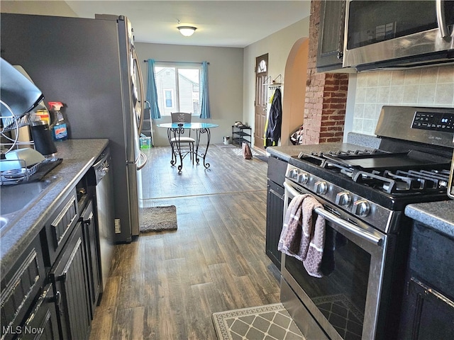 kitchen featuring backsplash, stainless steel appliances, and dark hardwood / wood-style floors