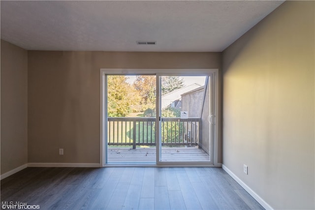 empty room with hardwood / wood-style flooring and a textured ceiling