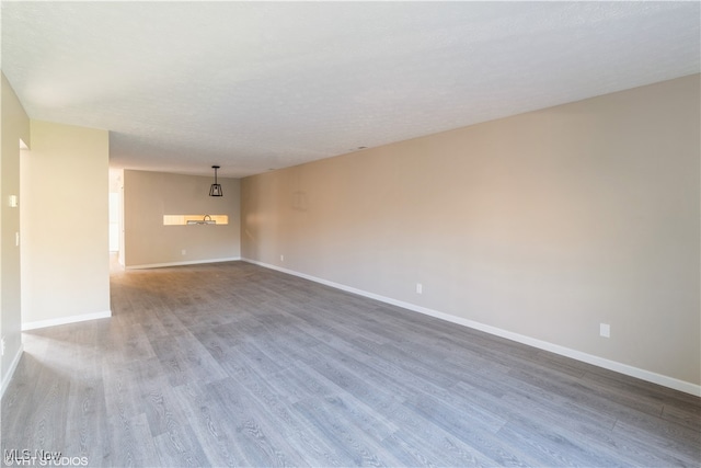 unfurnished room with dark wood-type flooring and a textured ceiling