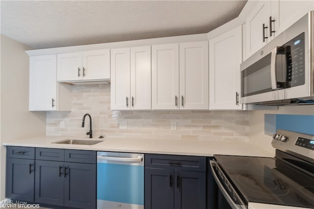 kitchen featuring white cabinets, a textured ceiling, stainless steel appliances, and sink
