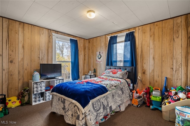 bedroom featuring carpet floors and wooden walls