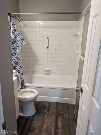 bathroom featuring tiled shower / bath combo, hardwood / wood-style flooring, and toilet