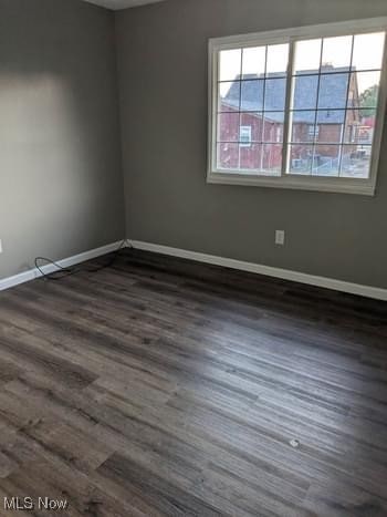 unfurnished room with dark hardwood / wood-style flooring