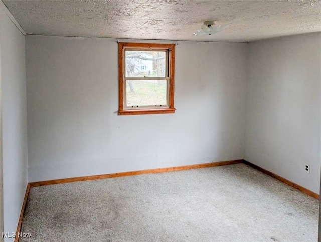 carpeted empty room featuring a textured ceiling