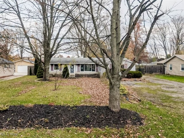 ranch-style house featuring an outbuilding and a front lawn