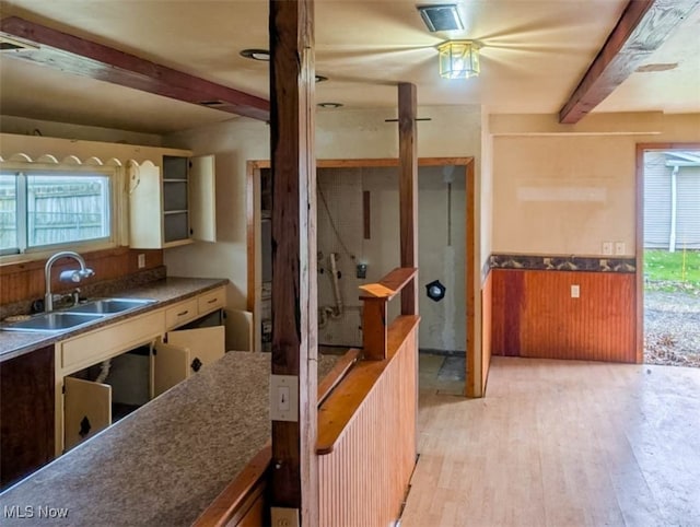 kitchen with beam ceiling, light hardwood / wood-style flooring, and sink