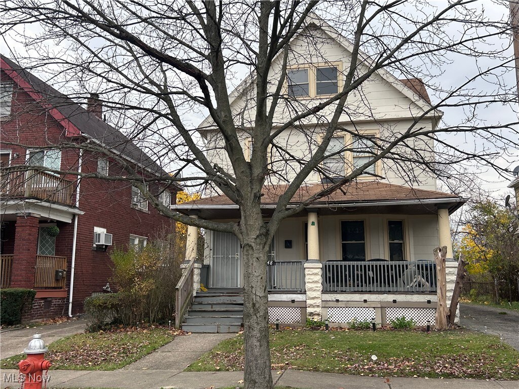 view of front facade featuring a porch and a wall unit AC