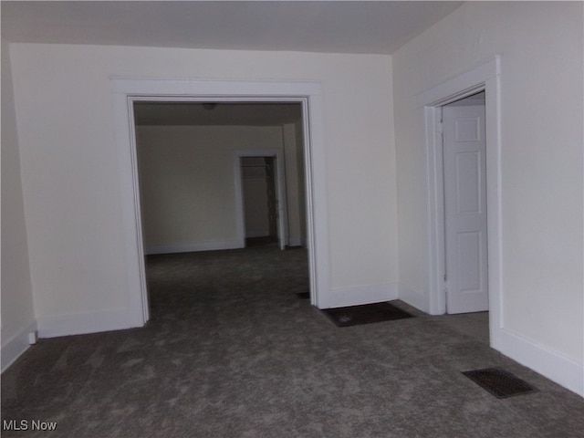 spare room with dark colored carpet