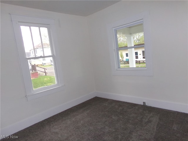 unfurnished room featuring dark colored carpet