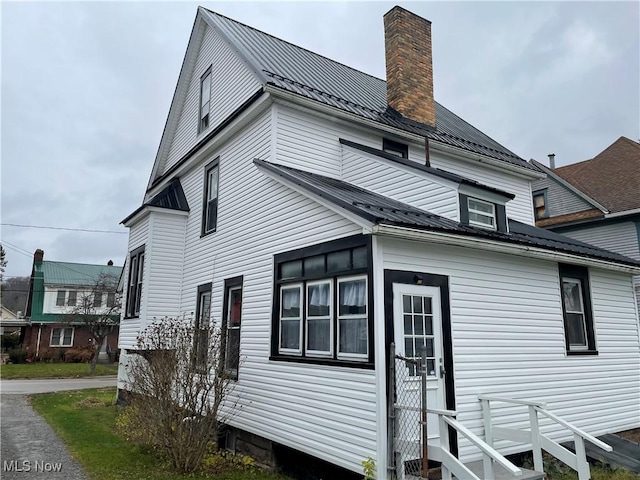 520 E Lincoln Way, Lisbon, OH 44432 - view of home's exterior featuring a chimney, metal roof, and entry steps
