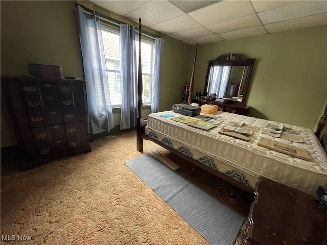 bedroom with carpet floors and a drop ceiling