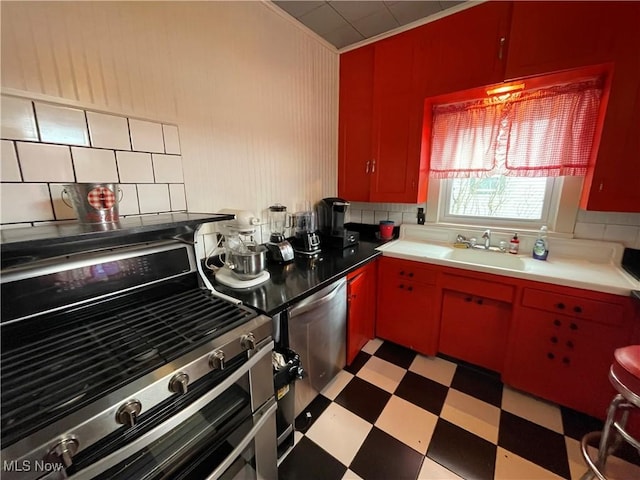 520 E Lincoln Way, Lisbon, OH 44432 - kitchen with light flooring, stainless steel appliances, red cabinetry, backsplash, and a sink