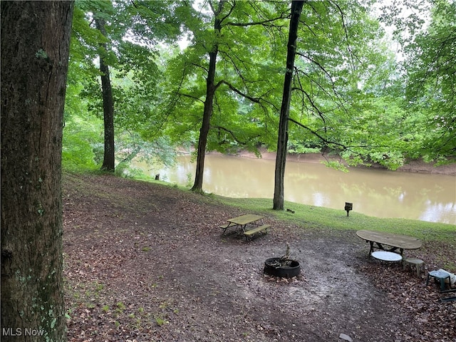 exterior space with a water view and a fire pit