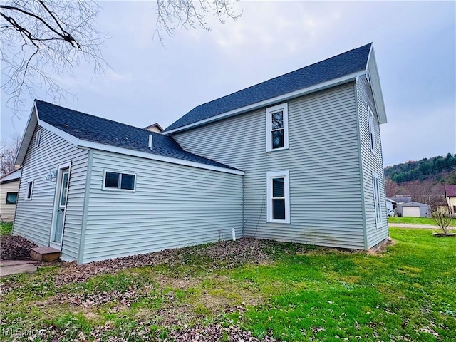 back of property featuring a lawn