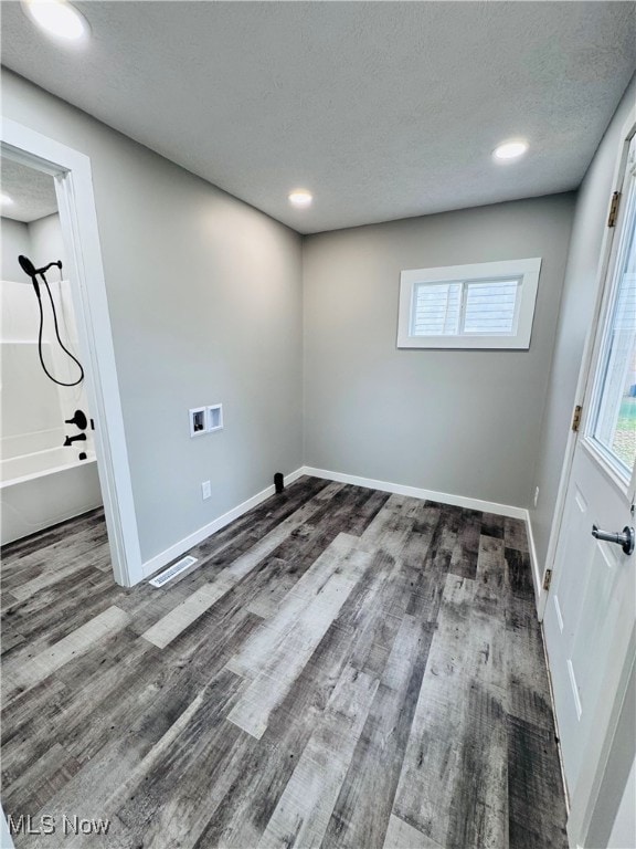 laundry room with washer hookup, dark wood-type flooring, and a textured ceiling