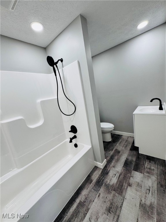 full bathroom with hardwood / wood-style floors, vanity, toilet, a textured ceiling, and shower / bath combination