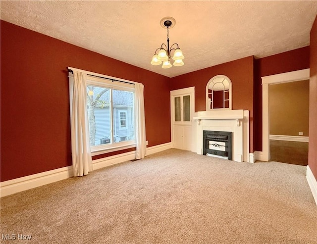 unfurnished living room with a textured ceiling, carpet floors, and a chandelier