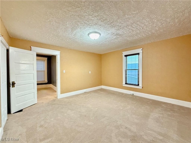 carpeted spare room featuring a textured ceiling