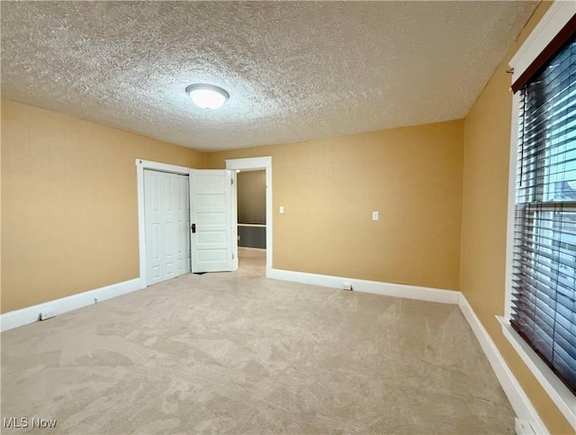 carpeted empty room with a textured ceiling