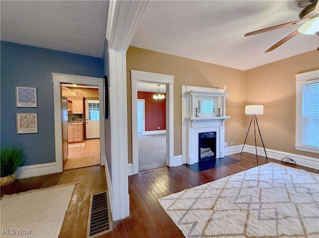 unfurnished bedroom featuring hardwood / wood-style flooring and ceiling fan with notable chandelier