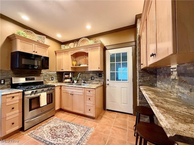 kitchen with light brown cabinetry, sink, light stone counters, crown molding, and stainless steel range with gas cooktop