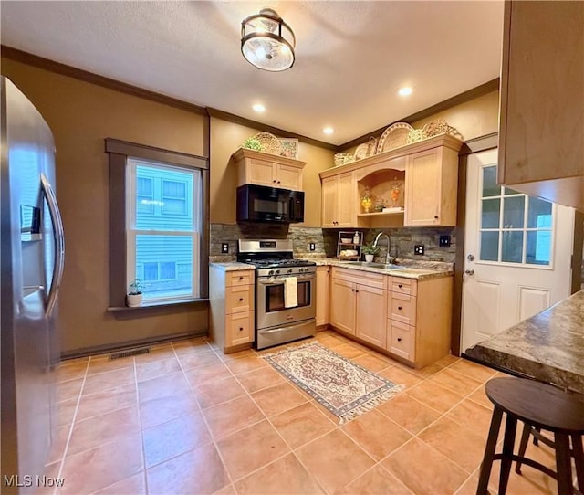 kitchen featuring light brown cabinetry, sink, light tile patterned floors, stainless steel appliances, and decorative backsplash