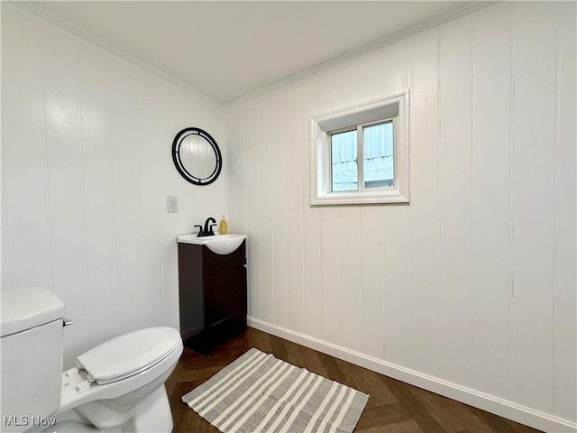 bathroom with vanity, wood-type flooring, ornamental molding, and toilet