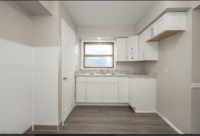 kitchen featuring white cabinetry, sink, and dark wood-type flooring