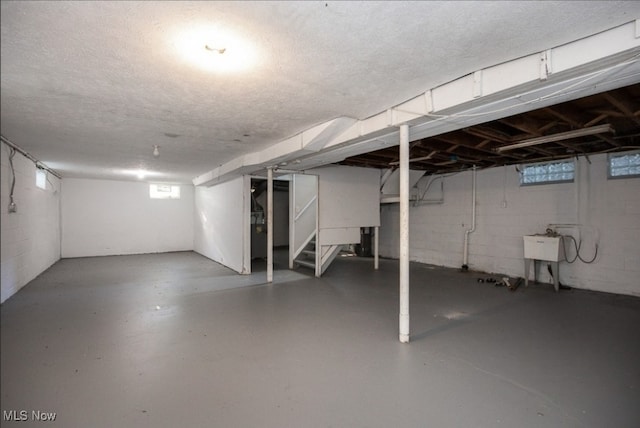 basement featuring a textured ceiling and sink