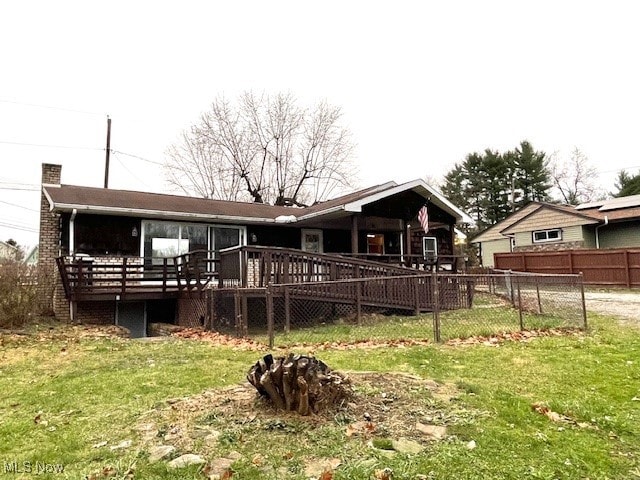 rear view of house with a yard and a deck