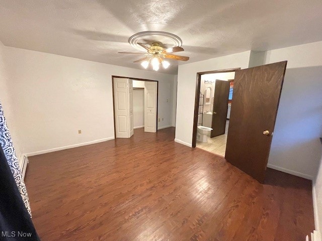 unfurnished bedroom with connected bathroom, ceiling fan, hardwood / wood-style floors, a textured ceiling, and a closet