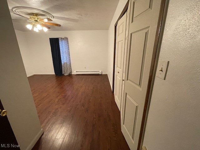 hall featuring baseboard heating and dark hardwood / wood-style flooring