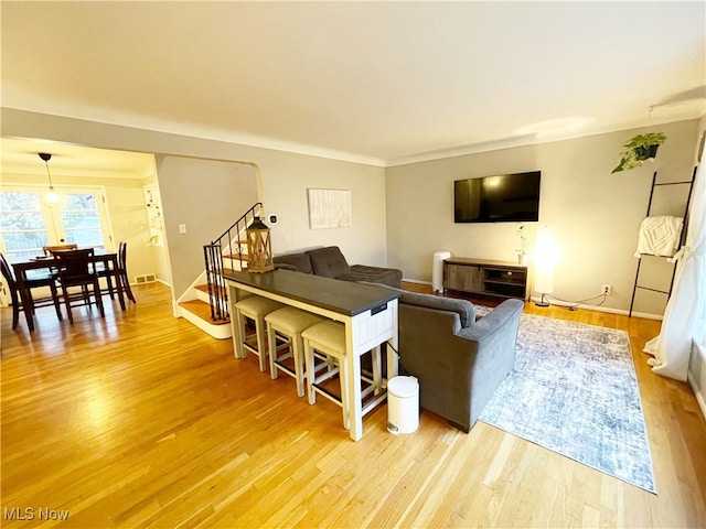 living room featuring light wood-type flooring and ornamental molding