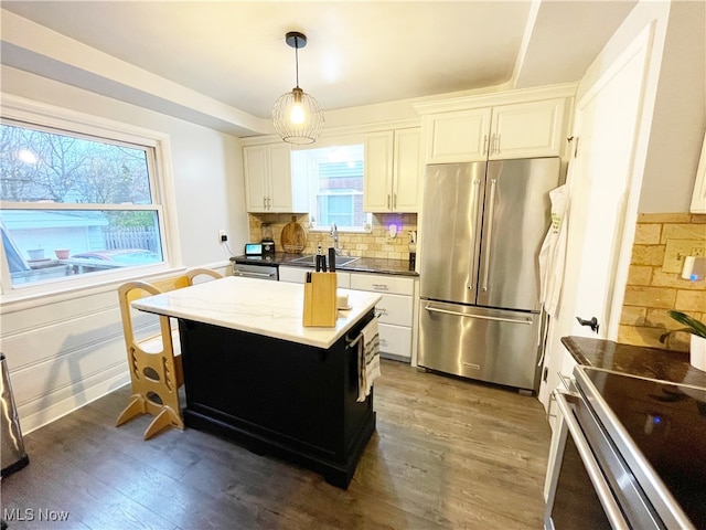 kitchen featuring pendant lighting, plenty of natural light, dark hardwood / wood-style floors, and appliances with stainless steel finishes