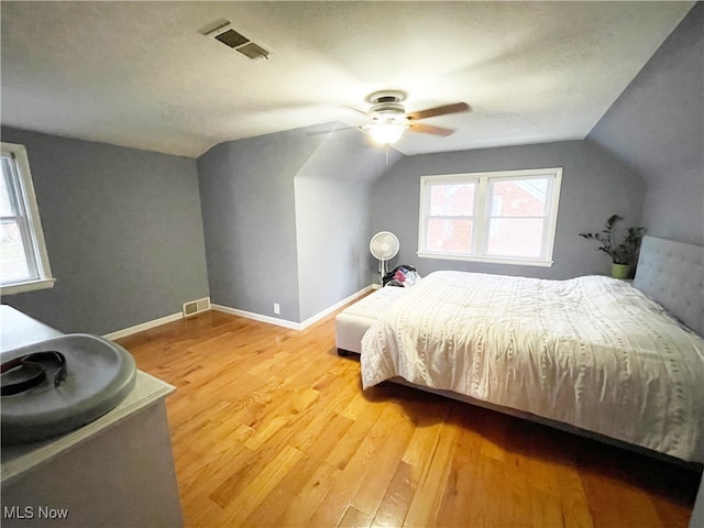 bedroom featuring ceiling fan, light hardwood / wood-style floors, and vaulted ceiling