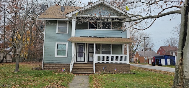 view of front of property with covered porch and a front lawn