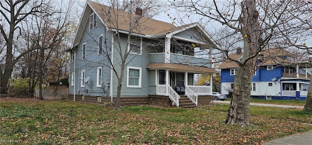 view of front of house with covered porch and a front lawn