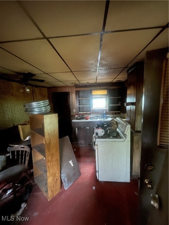 kitchen with a paneled ceiling and white gas stove