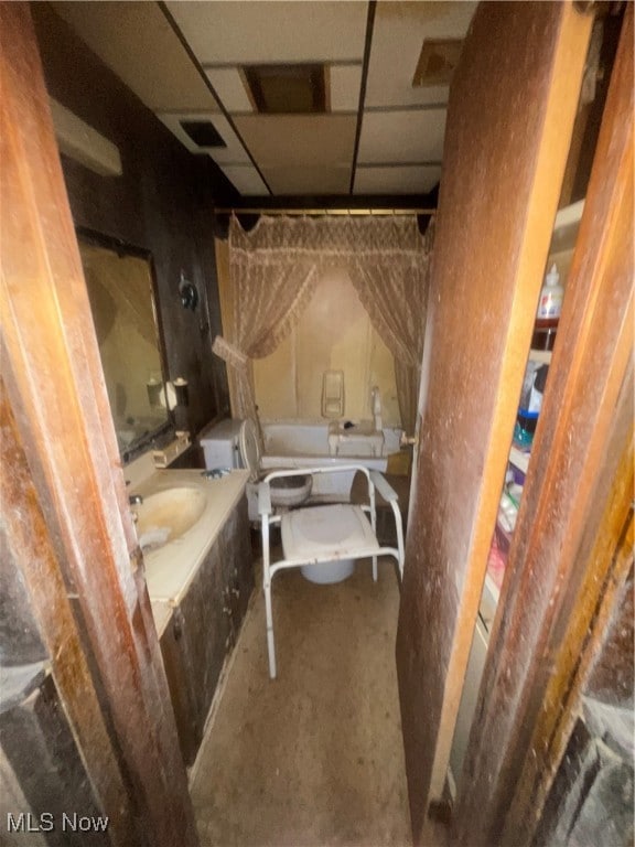 bathroom featuring a drop ceiling, shower / bathing tub combination, and toilet