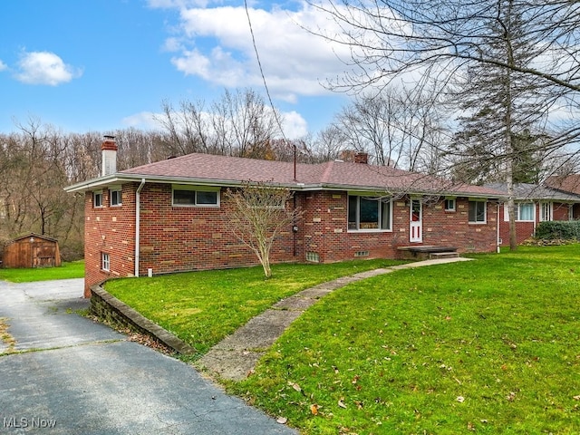 single story home with a front lawn and a storage shed