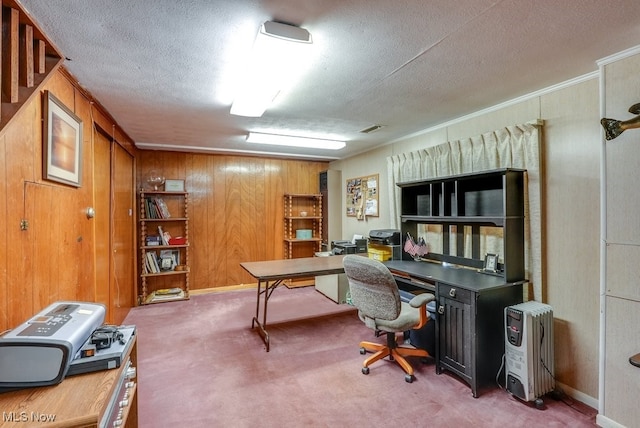 carpeted home office with a textured ceiling, heating unit, crown molding, and wood walls