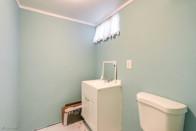 bathroom featuring vanity, ornamental molding, a textured ceiling, and toilet