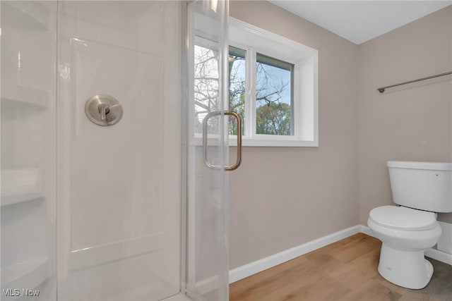 bathroom featuring toilet, wood-type flooring, and walk in shower